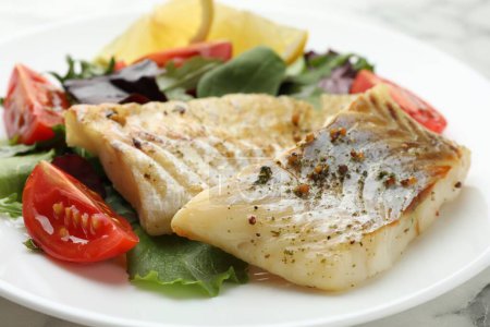 Foto de Sabroso bacalao cocido con ensalada en la mesa, primer plano - Imagen libre de derechos