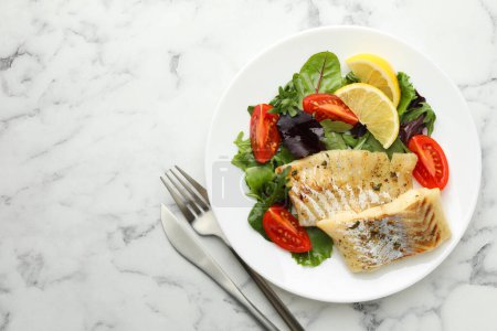 Foto de Sabroso bacalao cocido servido con ensalada sobre mesa de mármol blanco, tendido plano. Espacio para texto - Imagen libre de derechos