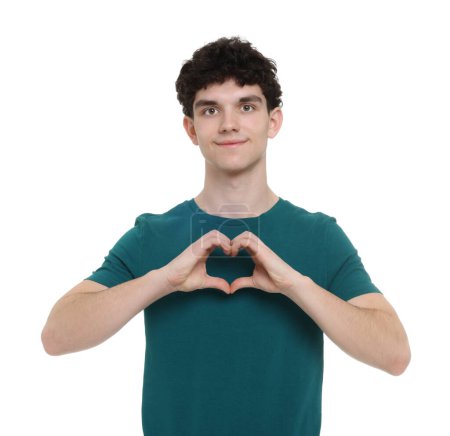 Téléchargez les photos : Jeune homme heureux montrant geste de coeur avec les mains sur fond blanc - en image libre de droit