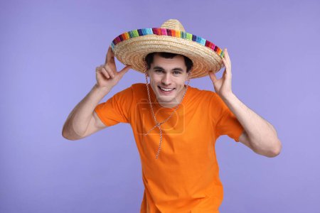 Joven con sombrero mexicano sobre fondo violeta