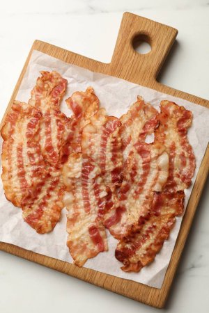 Photo for Delicious fried bacon slices on white marble table, top view - Royalty Free Image