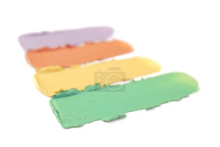 Samples of different color correcting concealers on white background, closeup