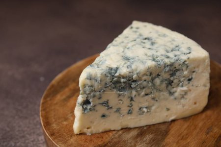 Morceau de savoureux fromage bleu sur table brune, gros plan. Espace pour le texte