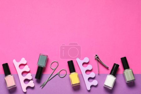 Foto de Esmaltes de uñas, cortauñas, tijeras y separadores de dedos en el fondo de color, disposición plana. Espacio para texto - Imagen libre de derechos