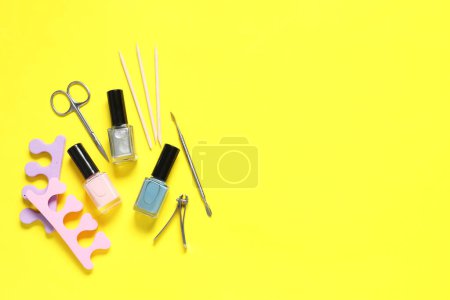 Foto de Esmaltes de uñas y juego de herramientas de pedicura sobre fondo amarillo, planas. Espacio para texto - Imagen libre de derechos
