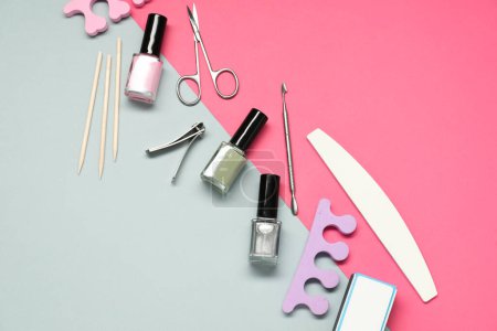 Foto de Esmaltes de uñas y conjunto de herramientas de pedicura sobre fondo de color, disposición plana - Imagen libre de derechos