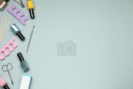 Foto de Esmaltes de uñas y juego de herramientas de pedicura sobre fondo gris, planas. Espacio para texto - Imagen libre de derechos