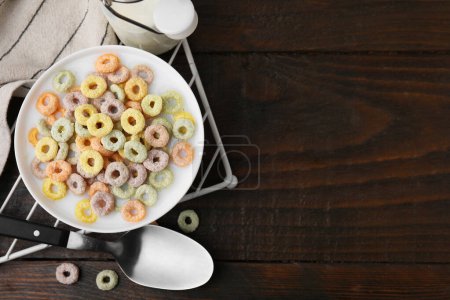 Photo for Cereal rings and milk in bowl on wooden table, top view. Space for text - Royalty Free Image