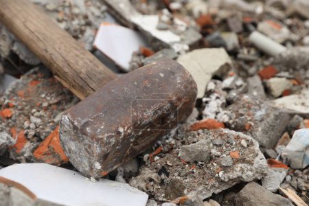 Sledgehammer on pile of broken bricks, closeup