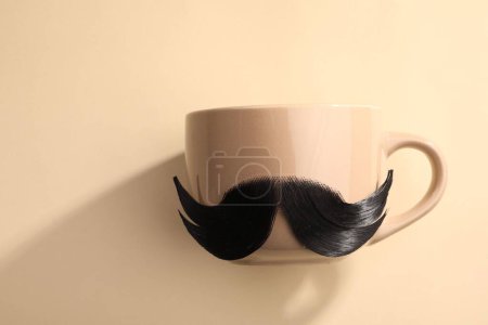 Téléchargez les photos : Moustache artificielle et tasse sur fond beige, vue de dessus - en image libre de droit