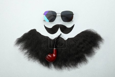 Téléchargez les photos : Composition à plat avec moustache artificielle et lunettes de soleil sur fond gris clair - en image libre de droit