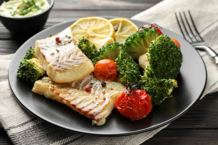 Foto de Sabroso bacalao cocido con verduras servido en la mesa - Imagen libre de derechos