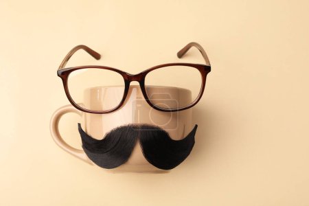 Téléchargez les photos : Moustache artificielle, tasse et verres sur fond beige, vue de dessus. Espace pour le texte - en image libre de droit