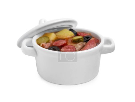 Téléchargez les photos : Soupe de viande solyanka avec de fines saucisses fumées sèches dans un pot isolé sur blanc - en image libre de droit
