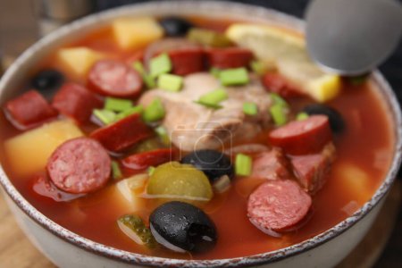 Téléchargez les photos : Soupe de viande solyanka avec de fines saucisses fumées sèches dans un bol, gros plan - en image libre de droit