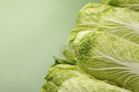 Fresh ripe Chinese cabbages on pale green background, closeup. Space for text