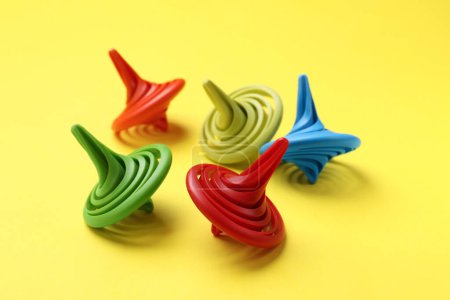 Photo for Many colorful spinning tops on yellow background, closeup - Royalty Free Image