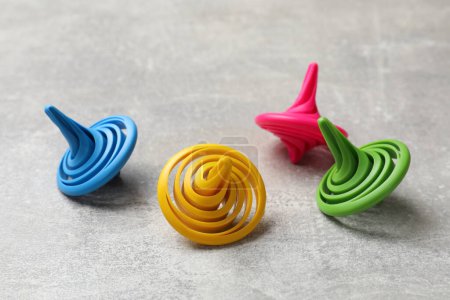 Photo for Bright spinning tops on grey textured background, closeup - Royalty Free Image