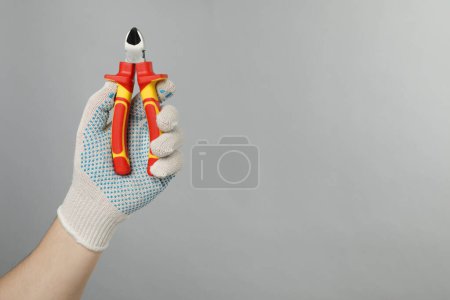 Photo for Man with diagonal pliers on grey background, closeup. Space for text - Royalty Free Image