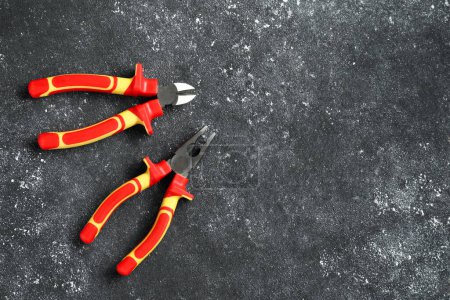Photo for Pliers on black textured table, flat lay. Space for text - Royalty Free Image