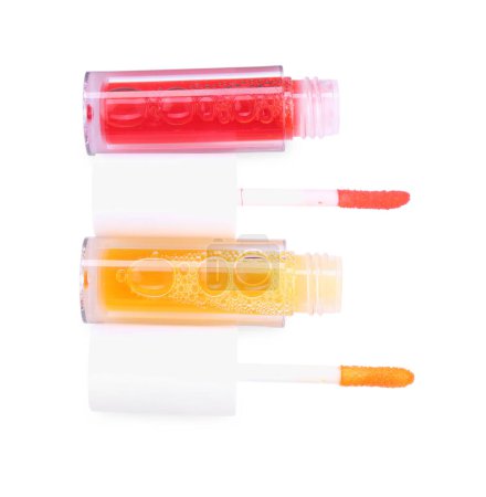 Foto de Brillos de labios y aplicadores aislados en blanco, vista superior - Imagen libre de derechos