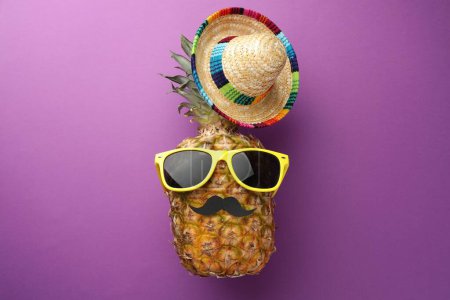 Téléchargez les photos : Ananas avec chapeau de sombrero mexicain, fausse moustache et lunettes de soleil sur fond violet, plat - en image libre de droit