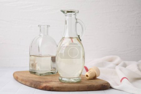 Foto de Vinagre en jarra de vidrio y botella sobre mesa blanca - Imagen libre de derechos