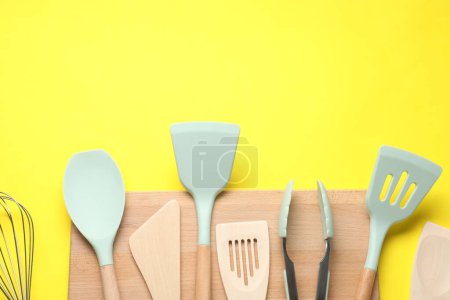 Téléchargez les photos : Différentes spatules et pinces sur fond jaune, plat. Espace pour le texte - en image libre de droit