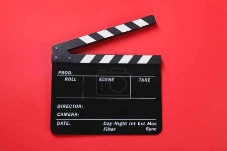 Clapperboard sobre fondo rojo, vista superior. Industria cinematográfica
