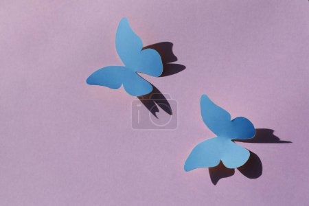 Photo for Bright light blue paper butterflies on violet background - Royalty Free Image