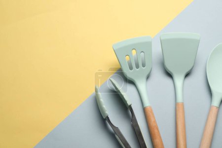 Téléchargez les photos : Différentes spatules et pinces sur fond de couleur, position plate. Espace pour le texte - en image libre de droit