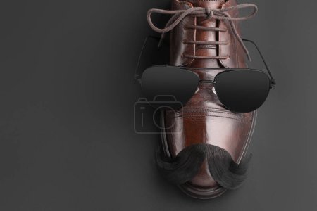Téléchargez les photos : Moustache artificielle, chaussures et lunettes de soleil sur fond noir, vue de dessus. Espace pour le texte - en image libre de droit