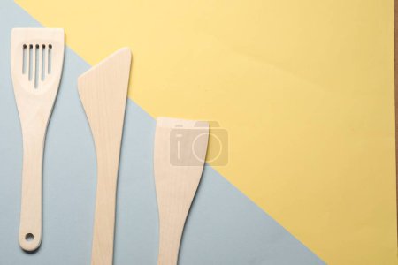 Téléchargez les photos : Différentes spatules en bois sur fond de couleur, pose plate. Espace pour le texte - en image libre de droit