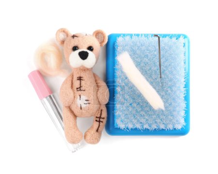 Téléchargez les photos : Aiguille d'ours feutré, laine et outils isolés sur blanc, vue de dessus - en image libre de droit