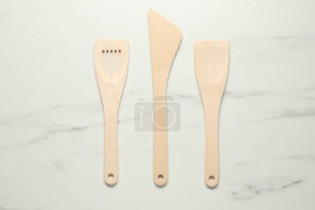 Téléchargez les photos : Différentes spatules en bois sur table en marbre blanc, pose plate - en image libre de droit