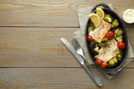 Foto de Sabroso bacalao cocido con verduras servidas sobre mesa de madera, aplanado. Espacio para texto - Imagen libre de derechos