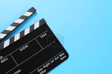 Clapperboard on light blue background, top view. Space for text