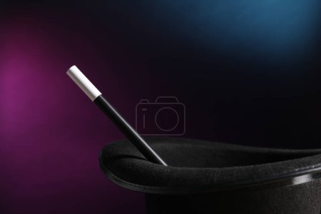 Magician's hat and wand on dark background, closeup