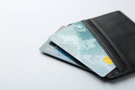 Téléchargez les photos : Femme tenant porte-cartes en cuir avec cartes de crédit sur fond gris clair, gros plan - en image libre de droit