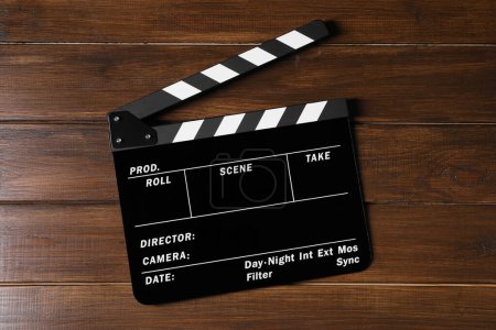 One clapperboard on wooden table, top view