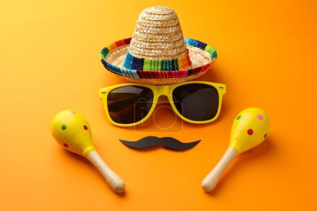 Téléchargez les photos : Chapeau sombrero mexicain, lunettes de soleil, fausse moustache et maracas sur fond orange - en image libre de droit
