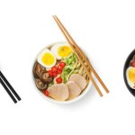 Set with bowls of delicious ramen with different ingredients and chopticks isolated on white, top view. Noodle soup