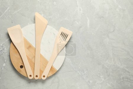 Téléchargez les photos : Différentes spatules en bois et planche sur table texturée grise, vue de dessus. Espace pour le texte - en image libre de droit
