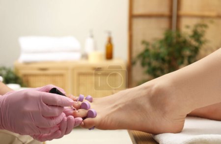 Photo for Professional pedicurist painting client`s toenails with polish in beauty salon, closeup - Royalty Free Image