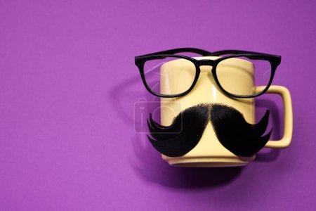 Téléchargez les photos : Visage d'homme fait de moustache artificielle, tasse et verres sur fond violet, vue de dessus. Espace pour le texte - en image libre de droit