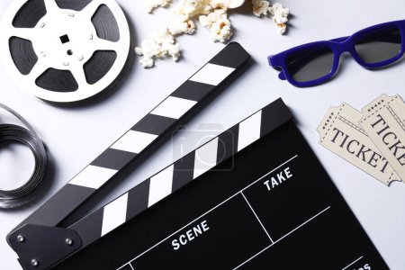 Flat lay composition with clapperboard, film reel and 3D glasses on grey background