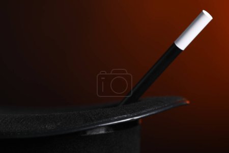 Magician's hat and wand on dark background, closeup