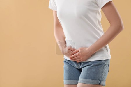 Photo for Woman suffering from cystitis on beige background, closeup. Space for text - Royalty Free Image