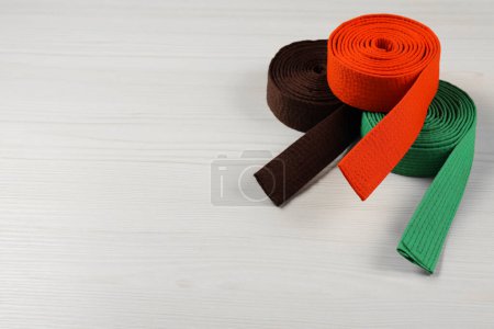 Photo for Colorful karate belts on wooden background, space for text - Royalty Free Image