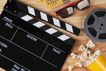 Flat lay composition with clapperboard and 3D glasses on wooden table